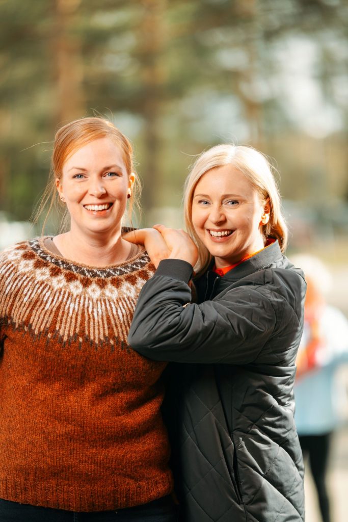 Kaksi hymyilevää ihmistä Järvenpään kampuksen pihalla