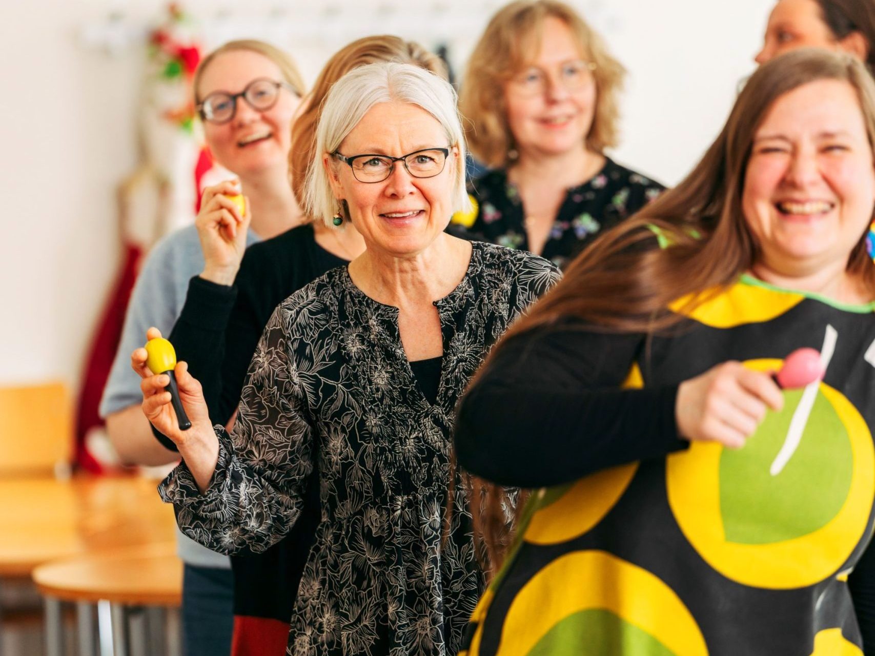 Koulutuksen osallistujat heiluttavat marakasseja